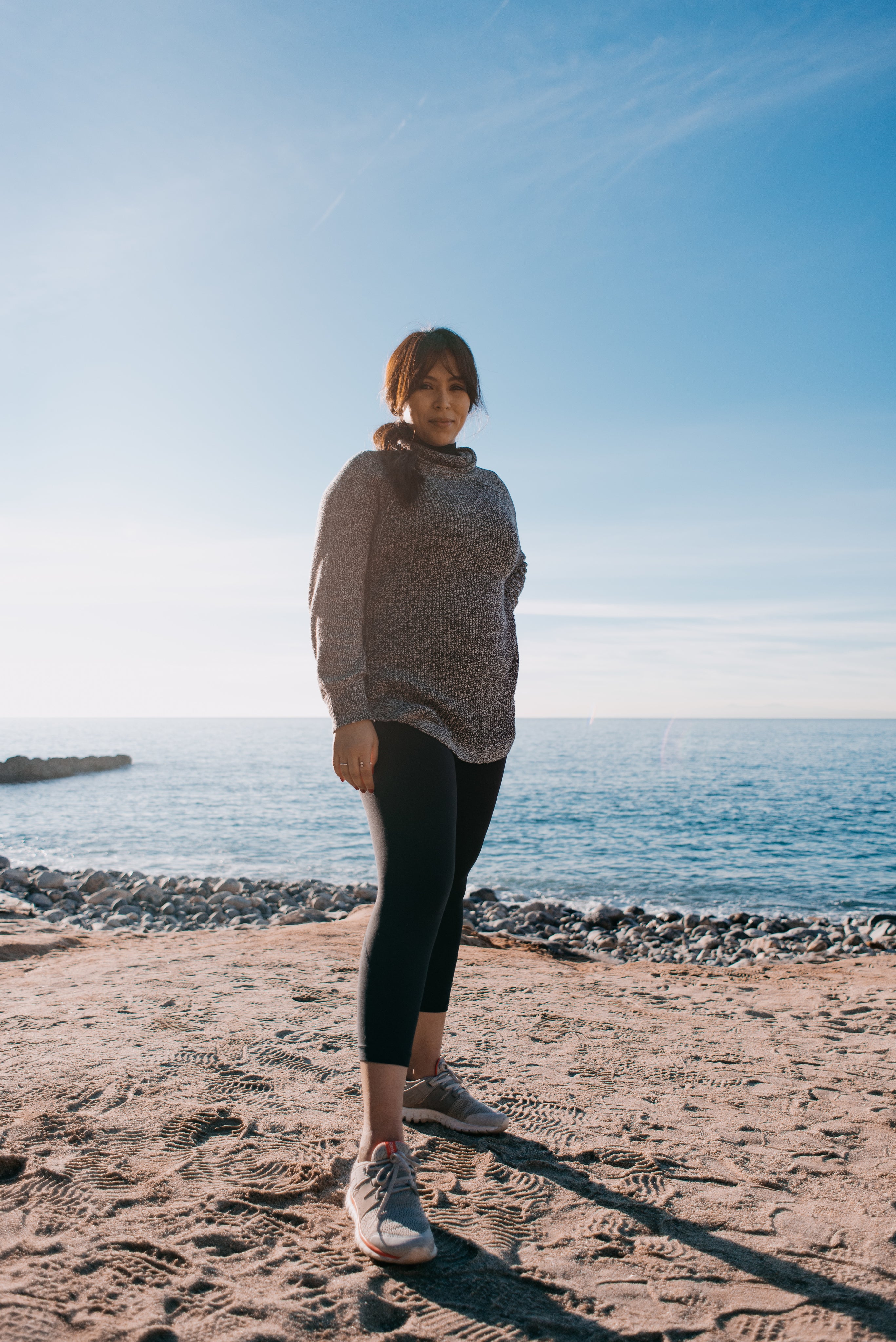 files/woman-in-a-sweater-stands-on-a-beach-in-the-morning.jpg